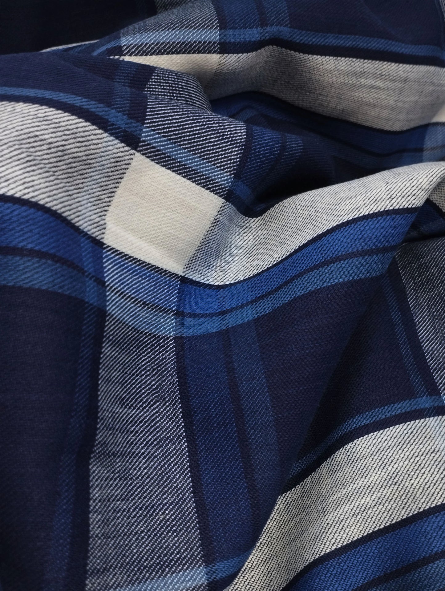 Close-up of navy blue and white checkered fabric with soft folds and textured weave