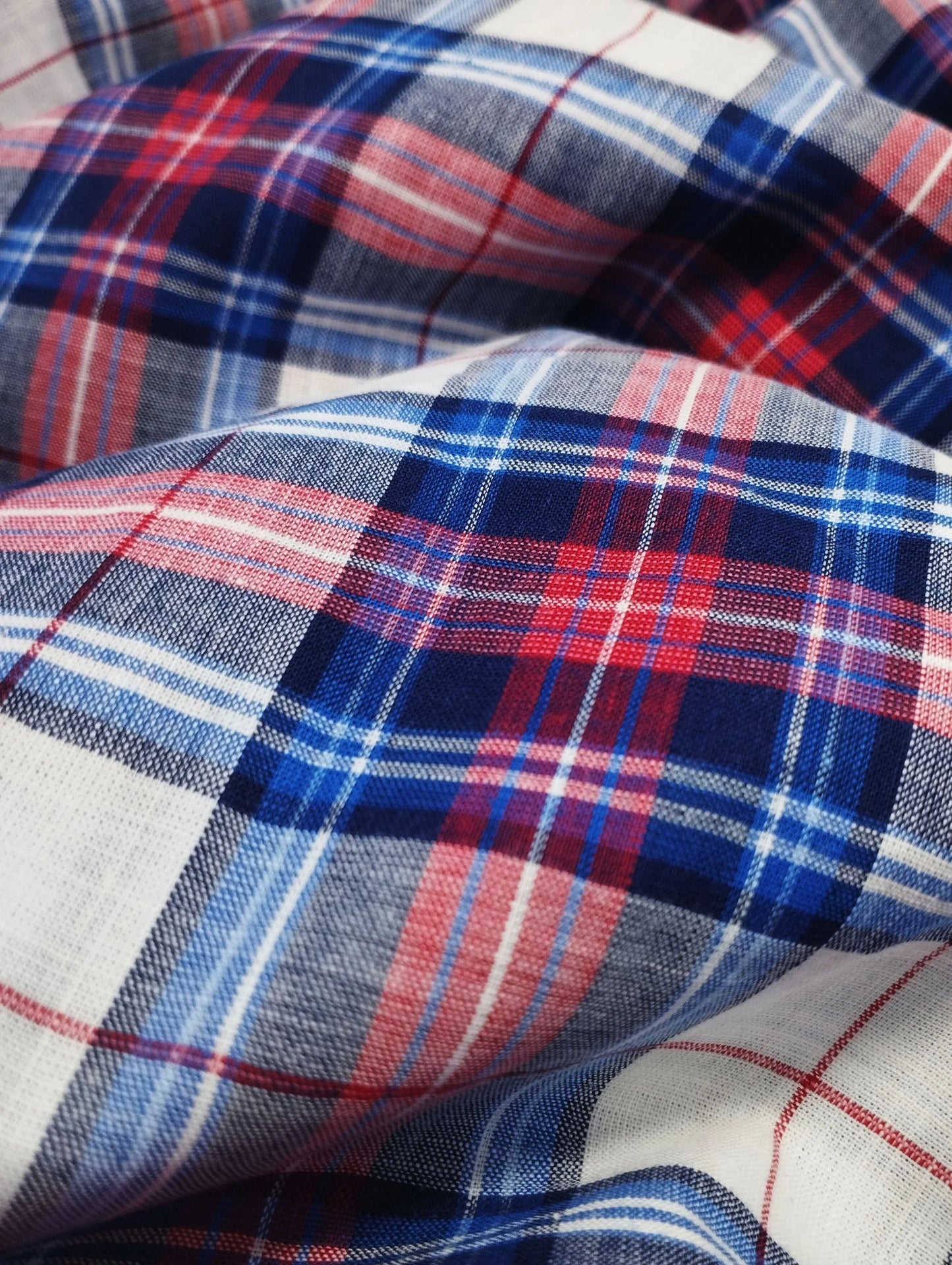 Close-up of red, blue, and white plaid fabric with detailed weave texture