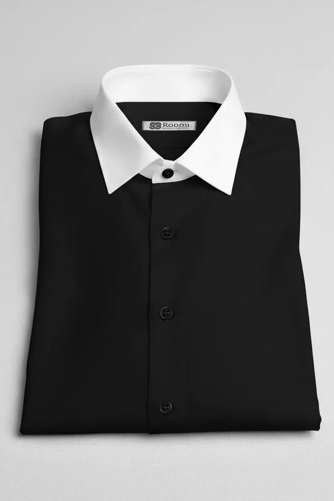Folded black dress shirt with white contrast collar and black buttons on white background