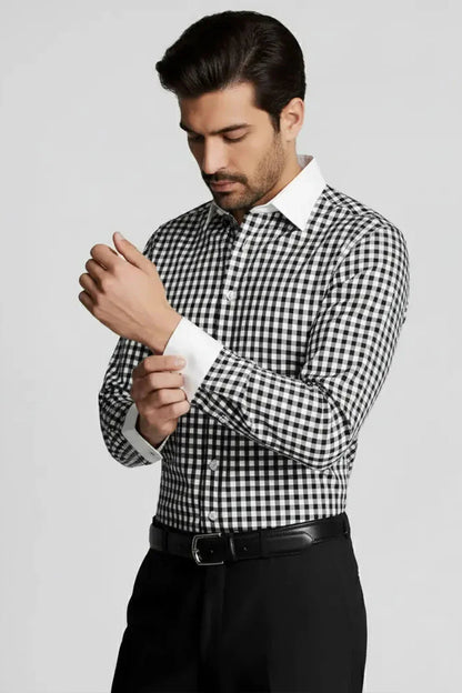Man adjusting cuff of black and white checkered dress shirt with white collar and cuffs