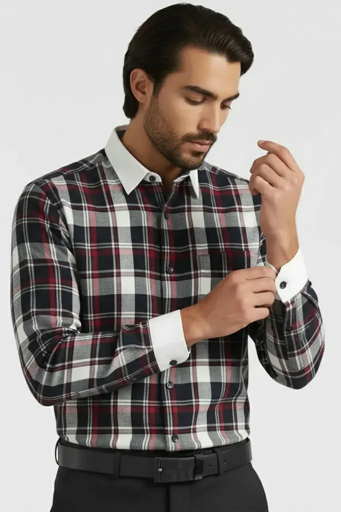 Man wearing black, white, and red plaid shirt with white collar and cuffs, adjusting sleeve button