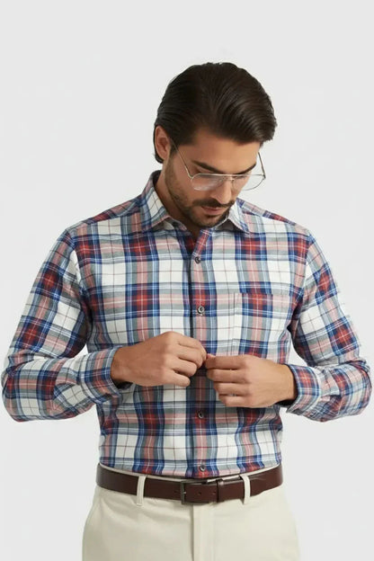 Man wearing red blue white plaid long-sleeve shirt buttoning front, styled with brown belt and cream pants